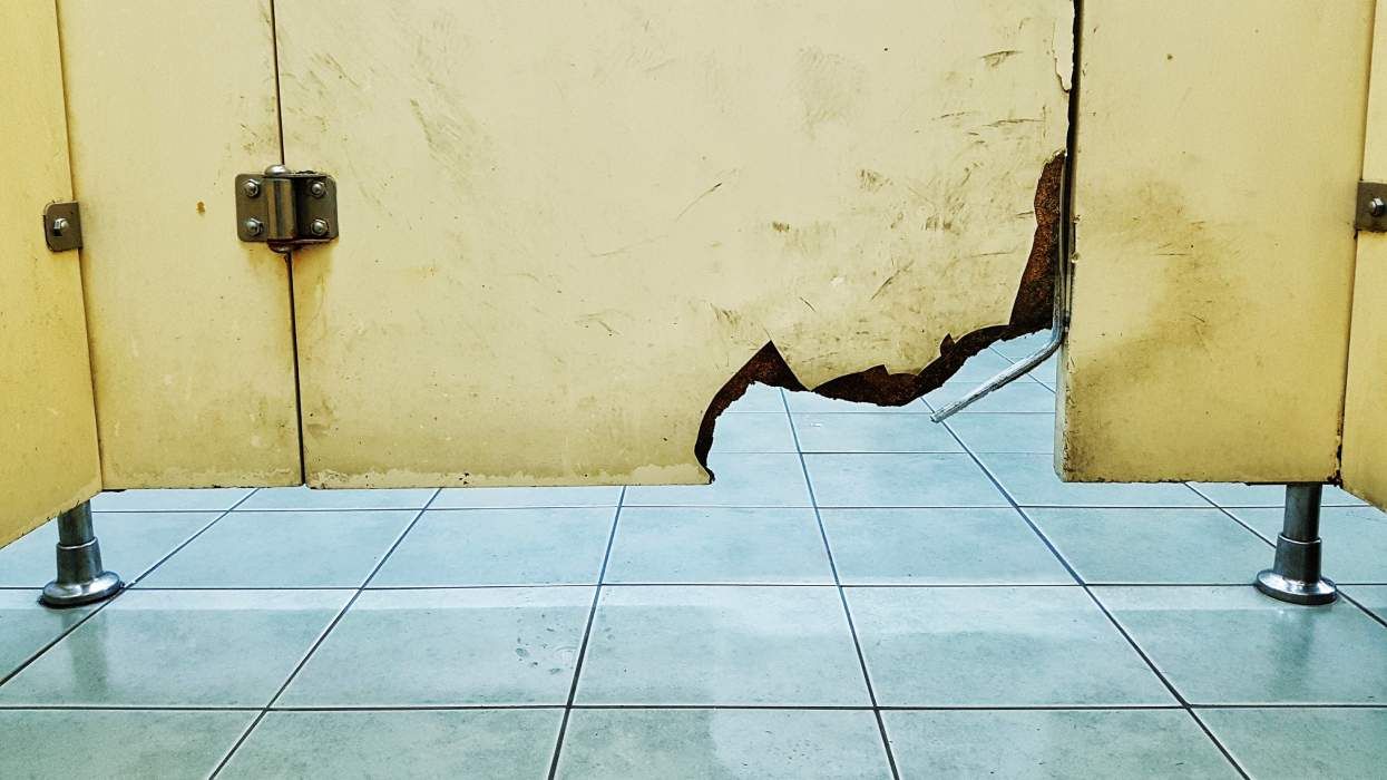 A bathroom stall door is broken