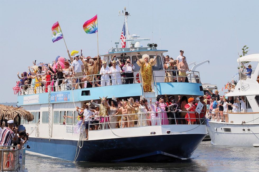 a boat carrying drag queens enters the harbor at fire island