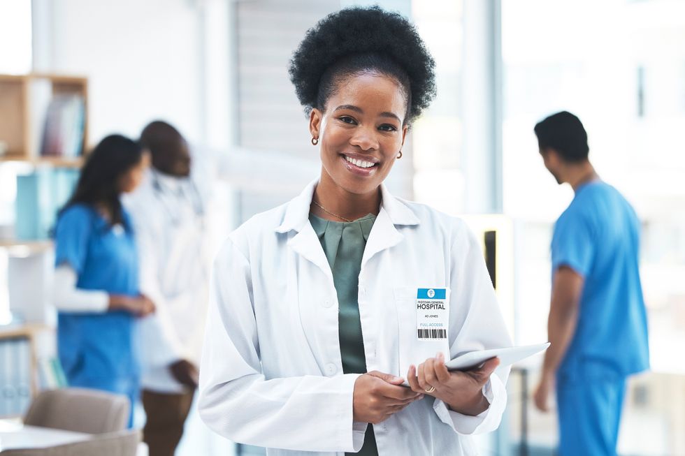 A doctor in a lab coat holding a tablet