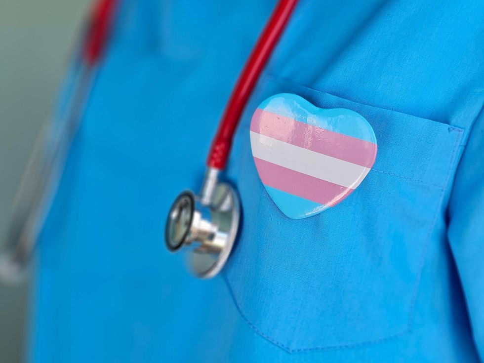 A doctor wearing a transgender pride pin