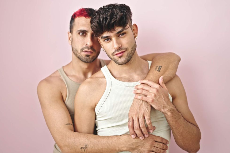 A gay man hugging his partner from behind