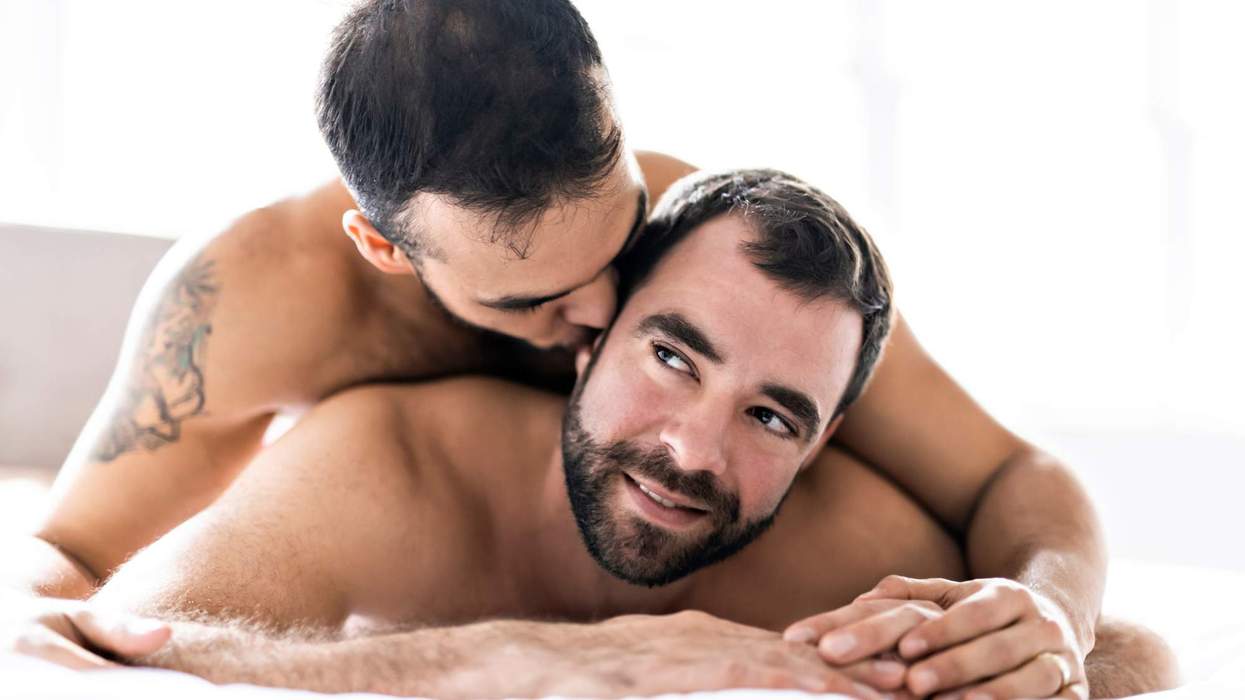 A gay man lying on top of another man