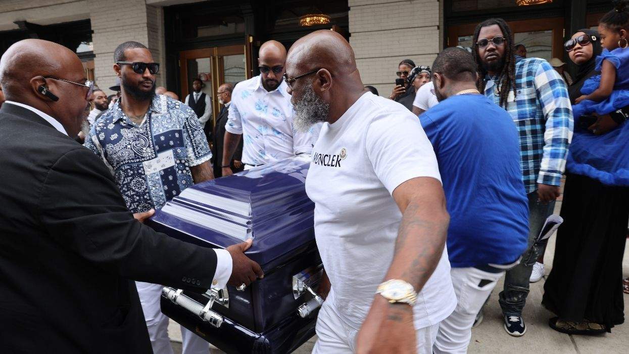 a group of people carrying a purple casket