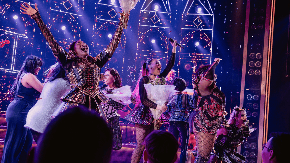 A group of performers on stage, celebrating their first performance as a group together.