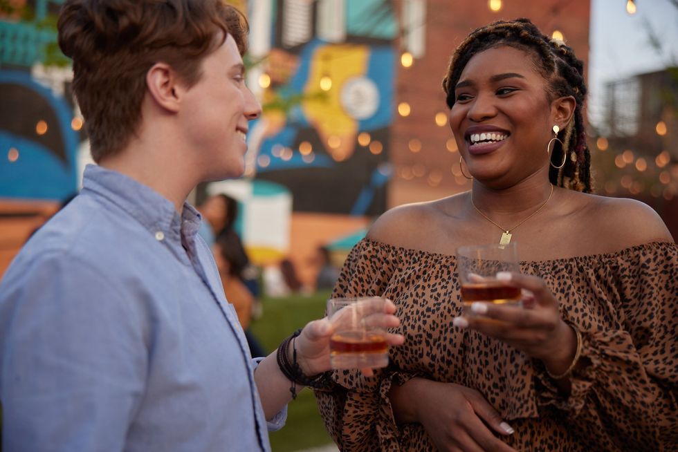 A man and a woman are enjoying bourbon together.