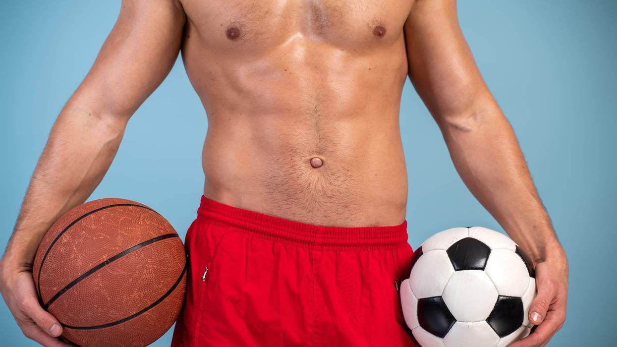 A man holding a basketball and a soccer ball.