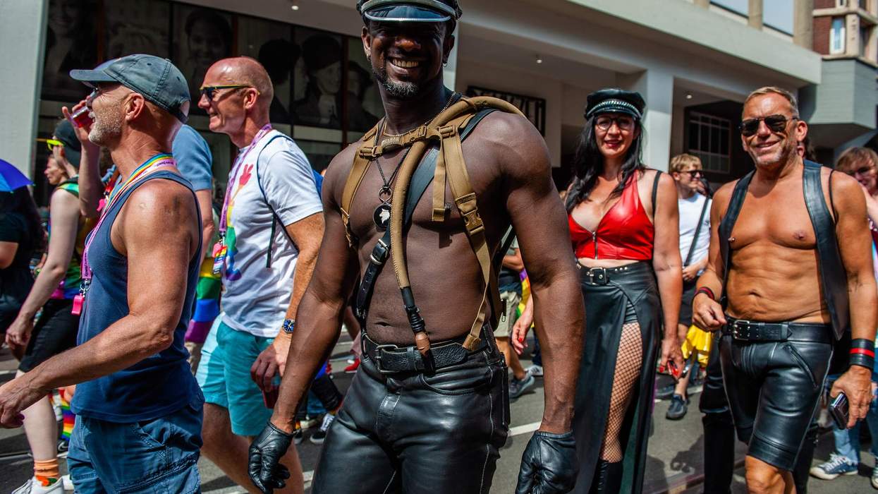 A man is wearing a leather harness while smiling to the camera. The annual equal rights demonstration for the global rainbow community took place in Amsterdam.