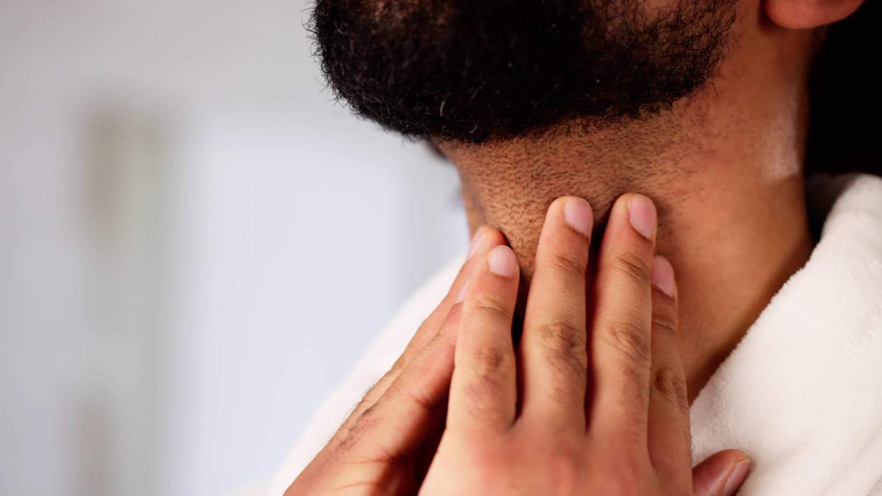 a man touching his throat to illustrate testosterone vocal fold injections