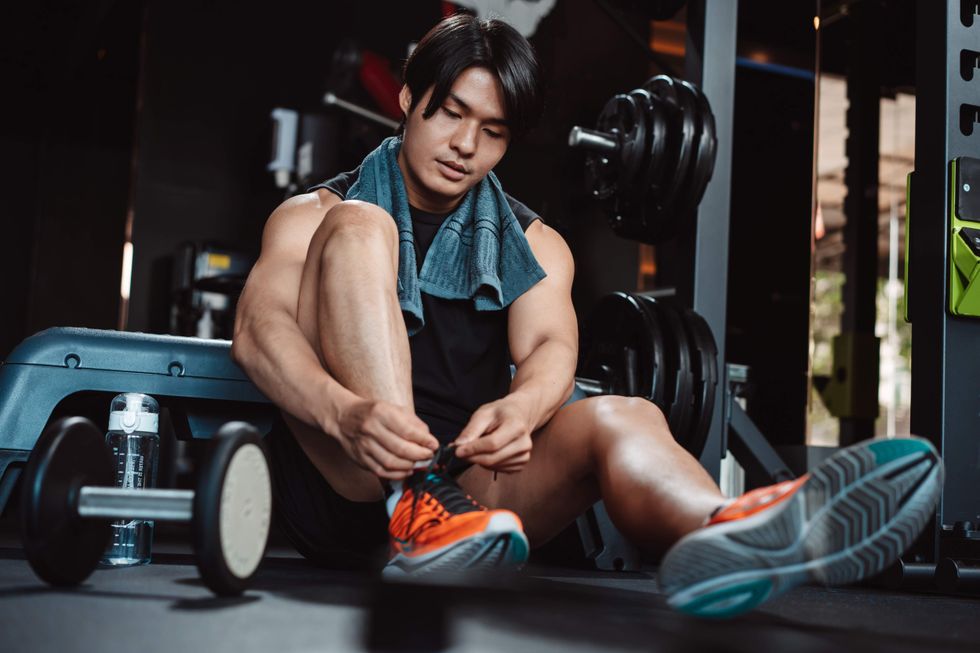 A man tying his shoe at the gym