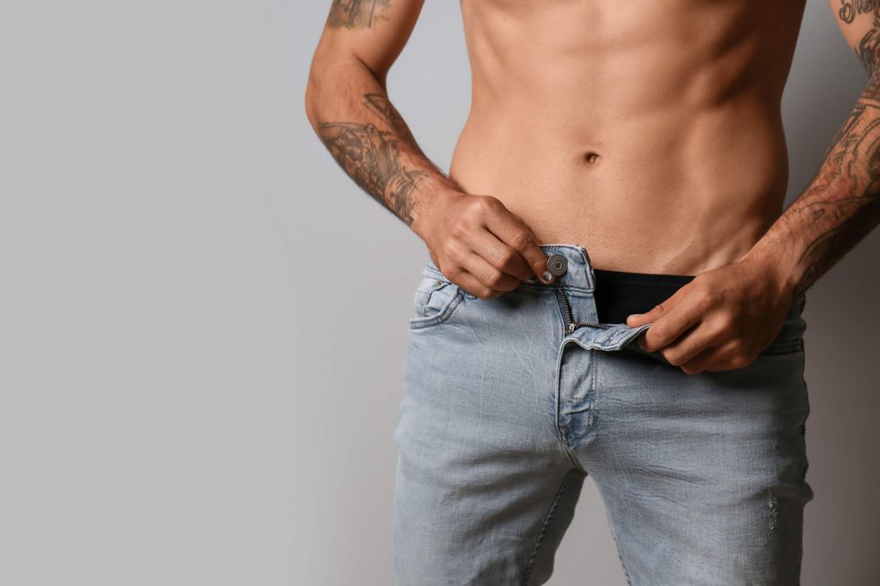 A man unzipping his jeans