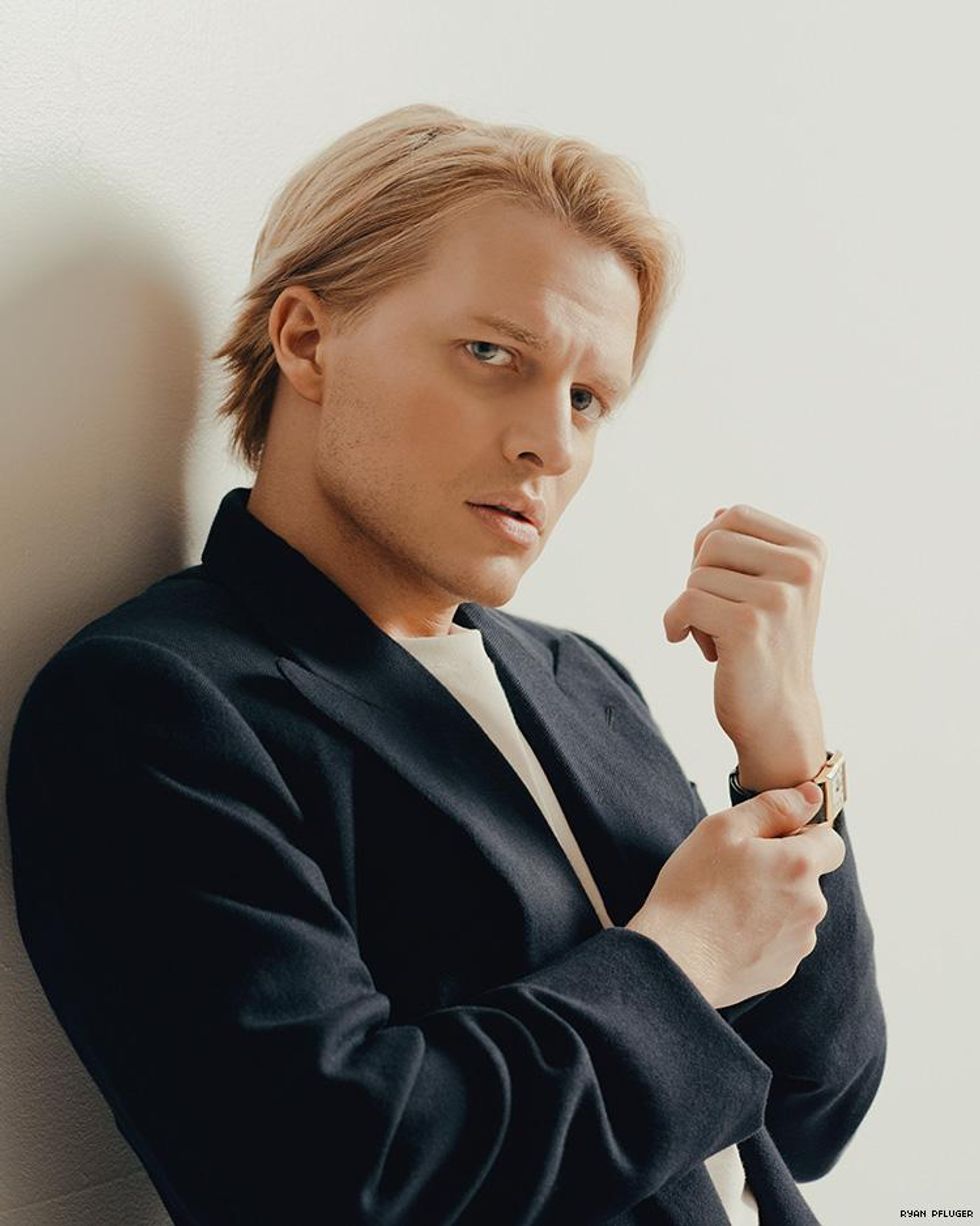 A profile portrait of Ronan Farrow leaning against a wall.