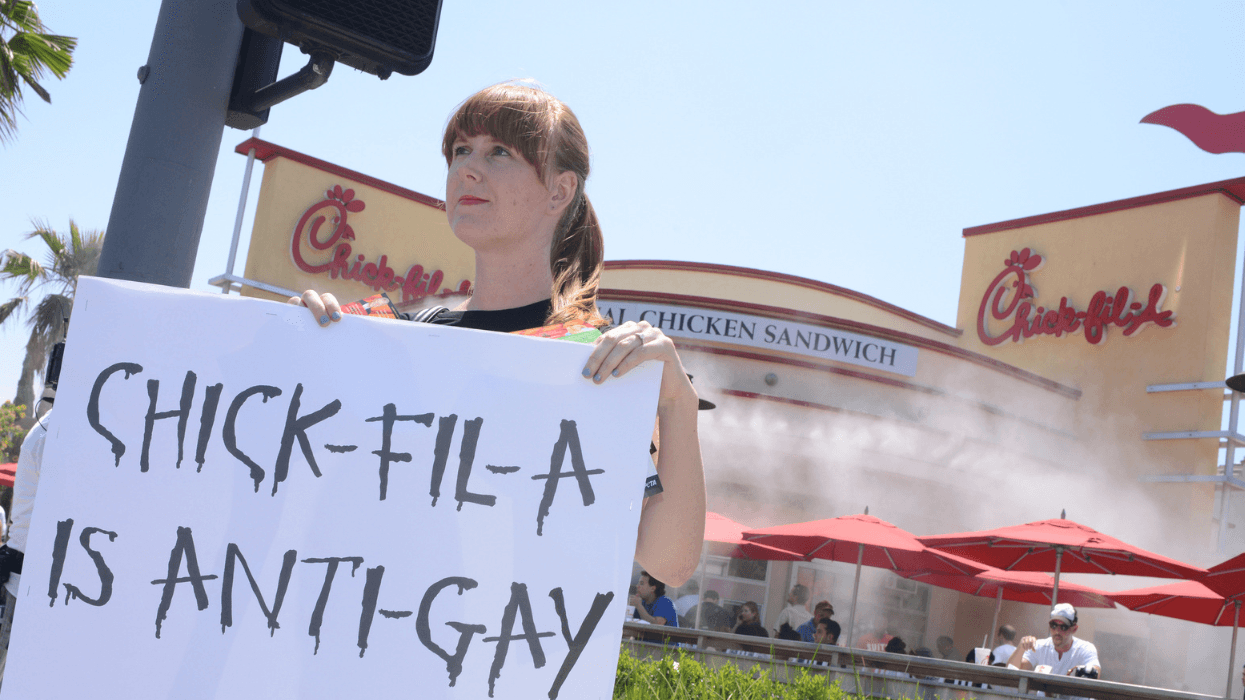 A protester holds a sign reading "Chick-fil-A is anti-gay" outside a Chick-fil-A restaurant in Hollywood, California.