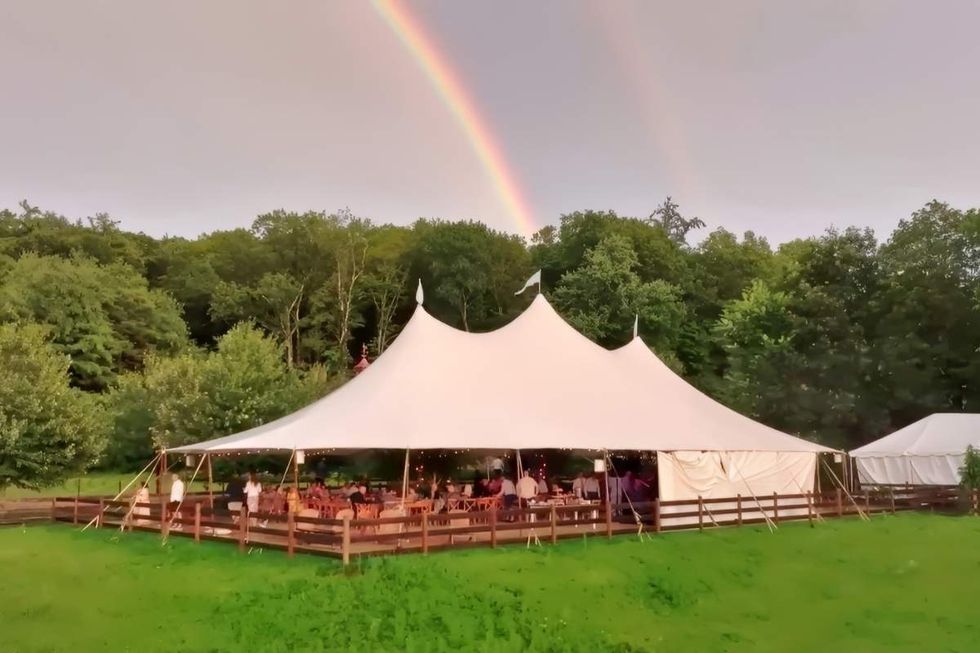 A rainbow is seen in the background of a scene on June Farms