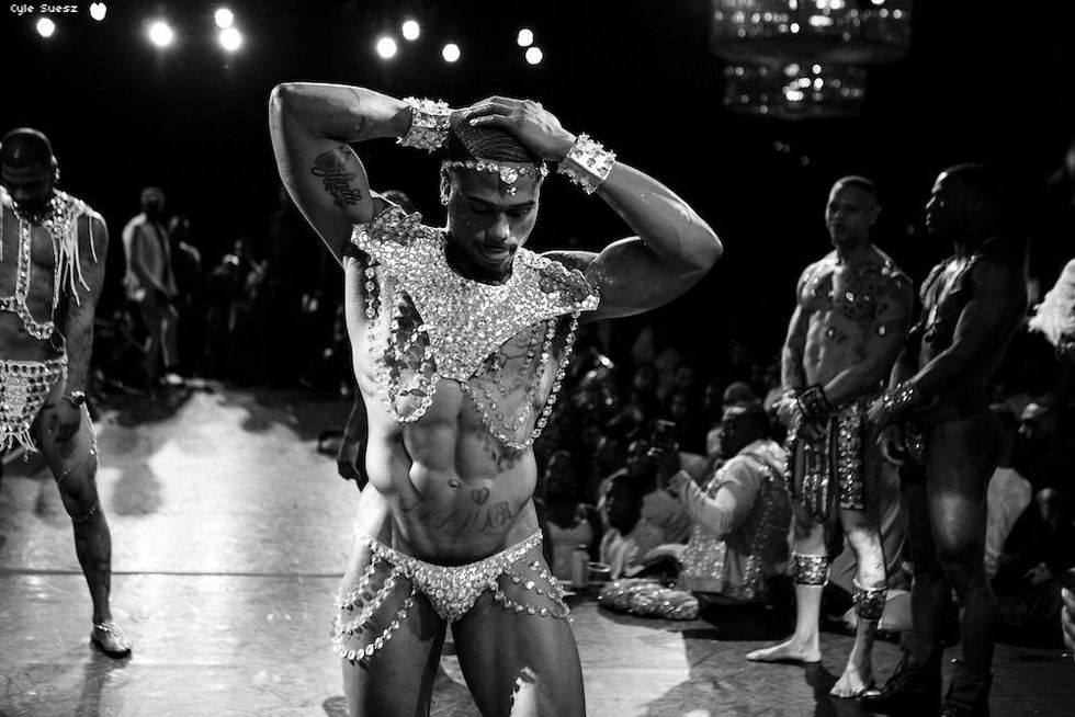 A shirtless man in a jeweled thong in the sex siren category.