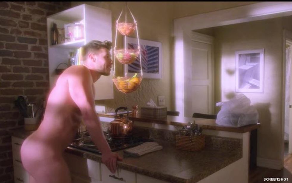 A shot from AJ and the Queen with a guy standing in a kitchen with no pants on.
