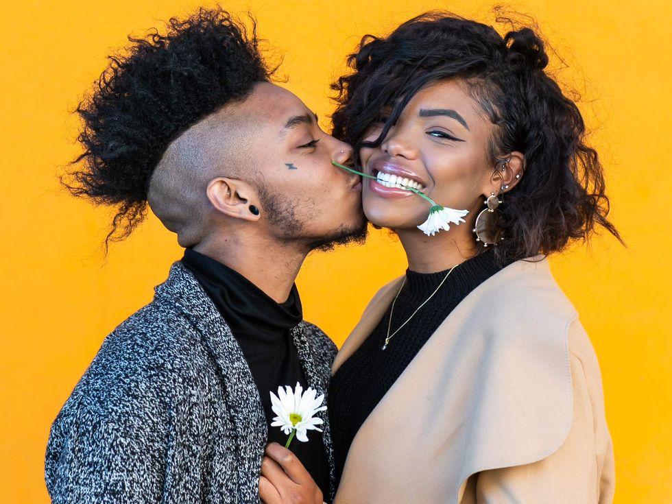 A trans man kissing a woman's cheek