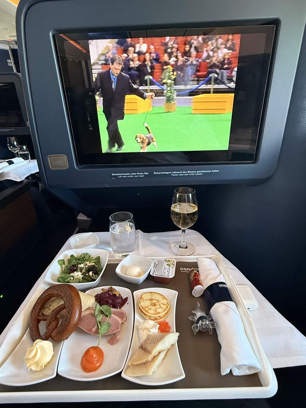 A tray of food with a movie playing on the screen