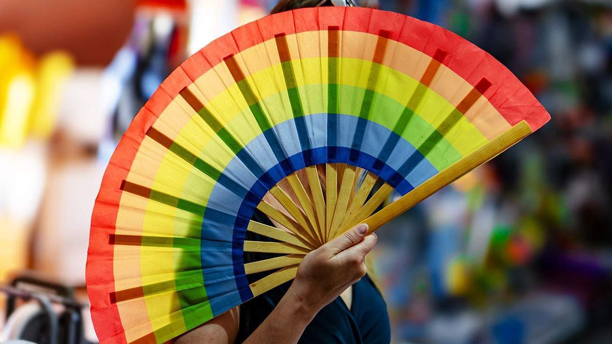 A woman holding a rainbow fan