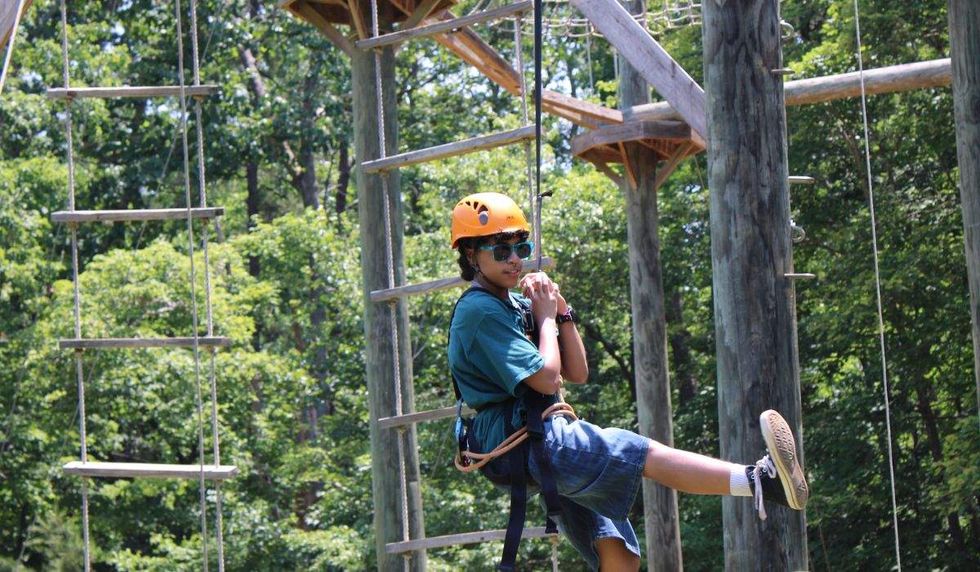 a young person conquering a ropes course