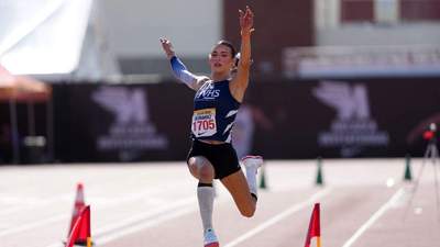 AB Hernandez mid-jump during a track and field event