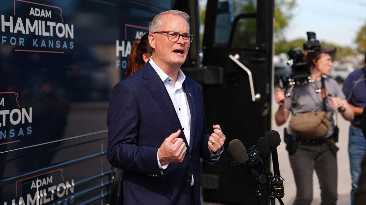 adam hamilton in front of a campaign bus