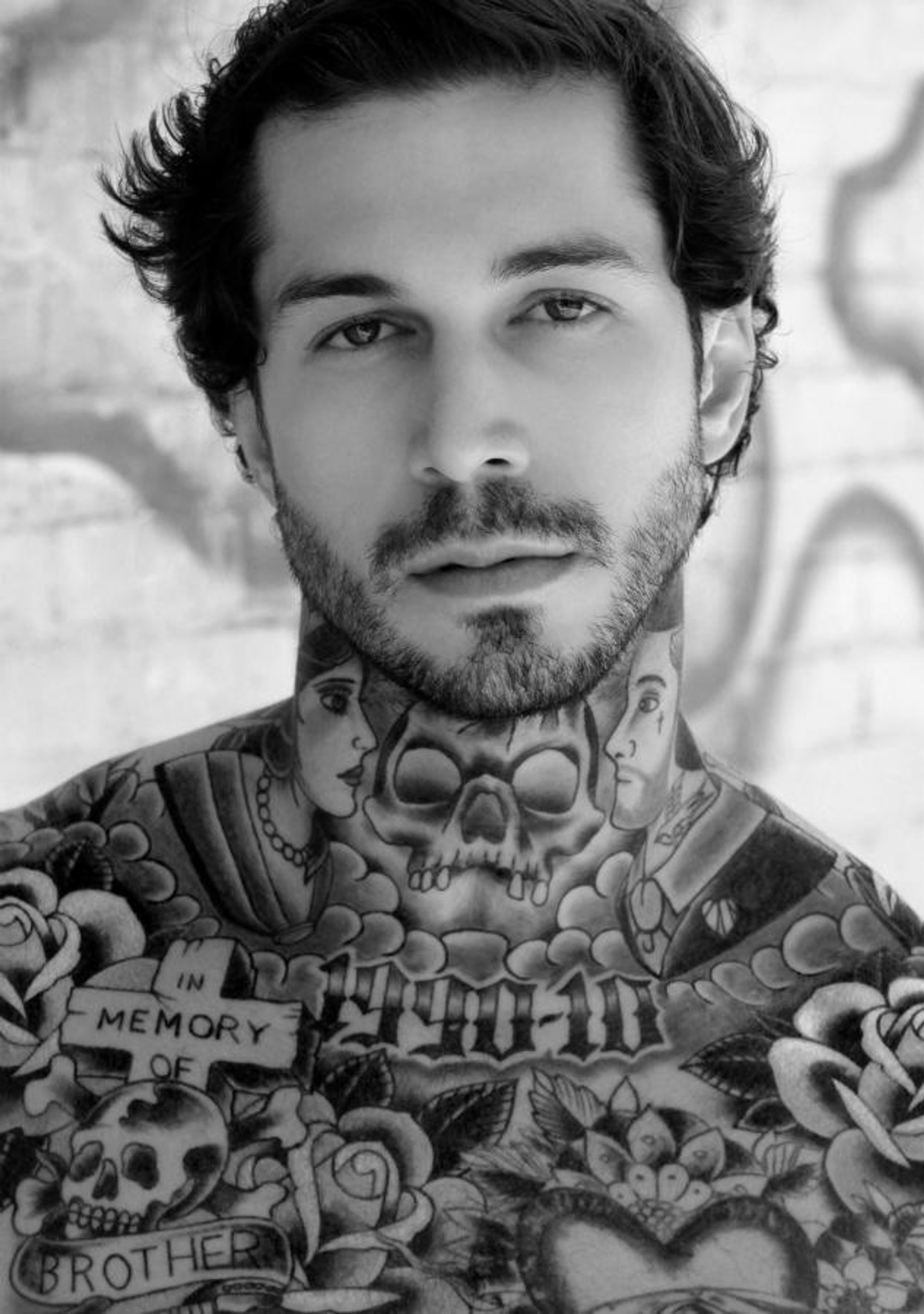 Close black-and-white Alex Minsky portrait showing the In Memory of Brother chest tattoo
