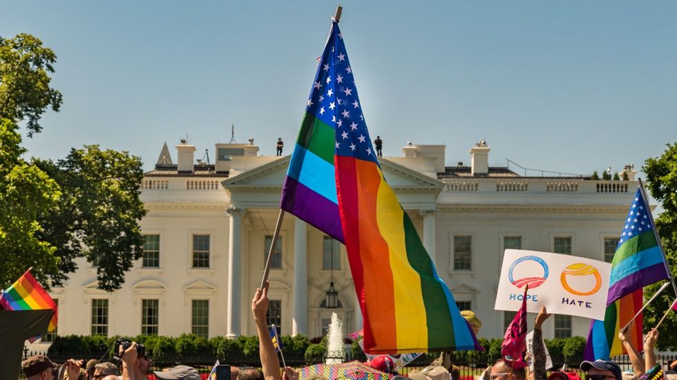 American flag with rainbow stripes outside U.S. capitol 