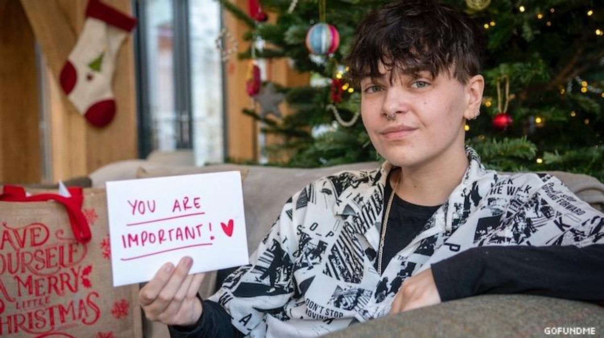 An image of a man holding a holiday card he made.