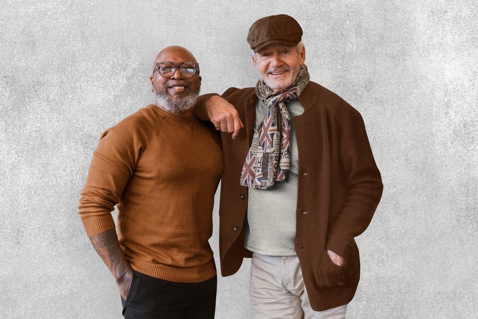 An older gay couple leaning against each other.