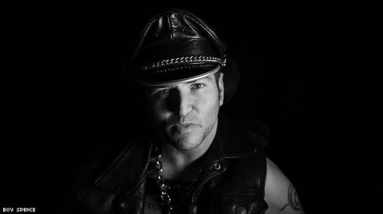 Andrew Gurza in a leatherman's cap and motorcycle jacket.