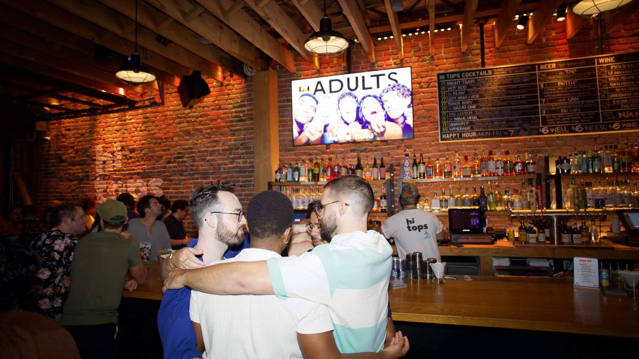 Bar scene with friends hugging near a counter, under a lit "Adults" sign.