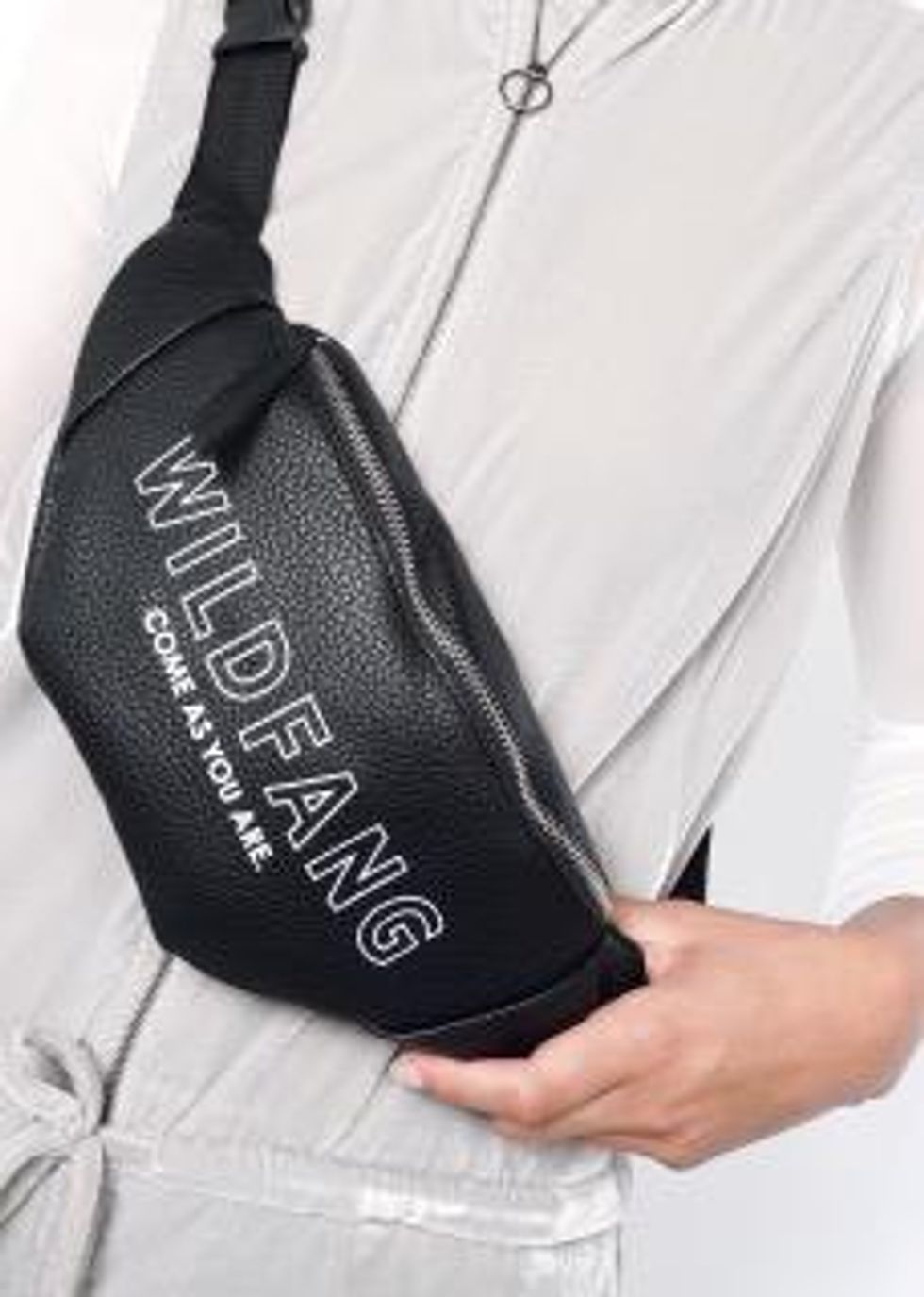 Black faux leather fanny pack with silver writing. Wildfang, come as you are.