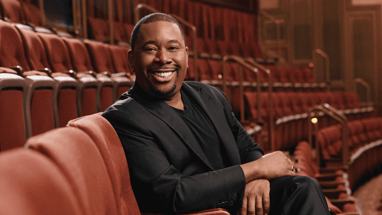 Brian Anthony Moreland seated in a Broadway theater, smiling and wearing a black suit