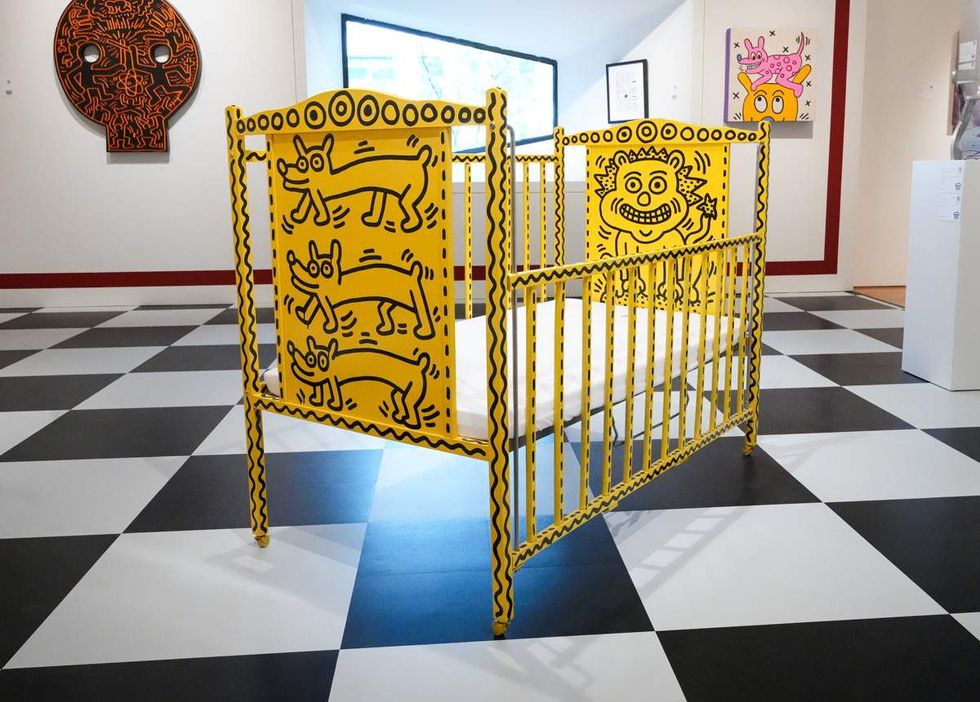 bright yellow baby crib with black drawings by keith haring circa 1986