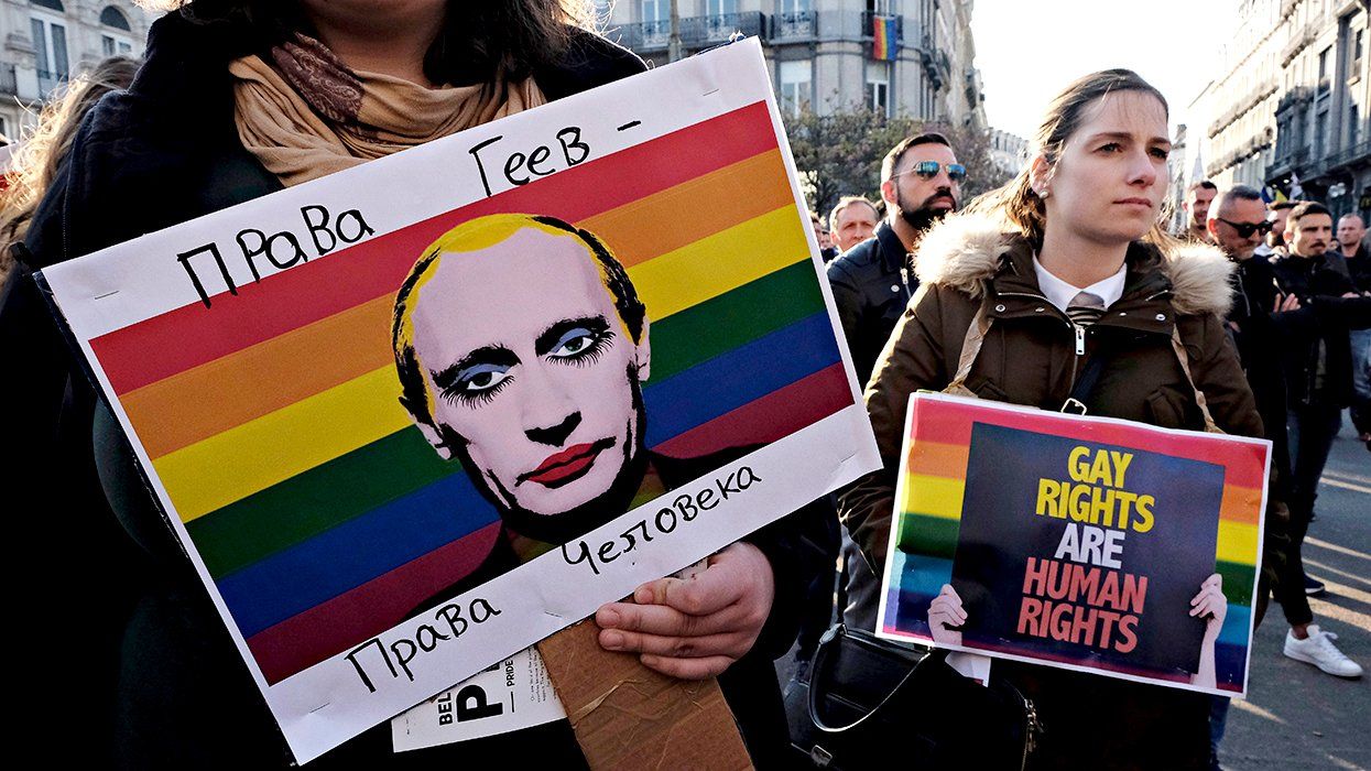 Brussels Belgium protest sign showing Russian President Vladimir Putin in drag makeup against a rainbow another says gay rights human rights during protest against the detention of gay men in concentration camps in Chechnya
