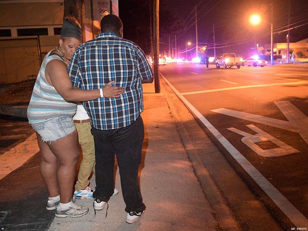 Bystanders wait down the street from the multiple shooting at the Pulse.