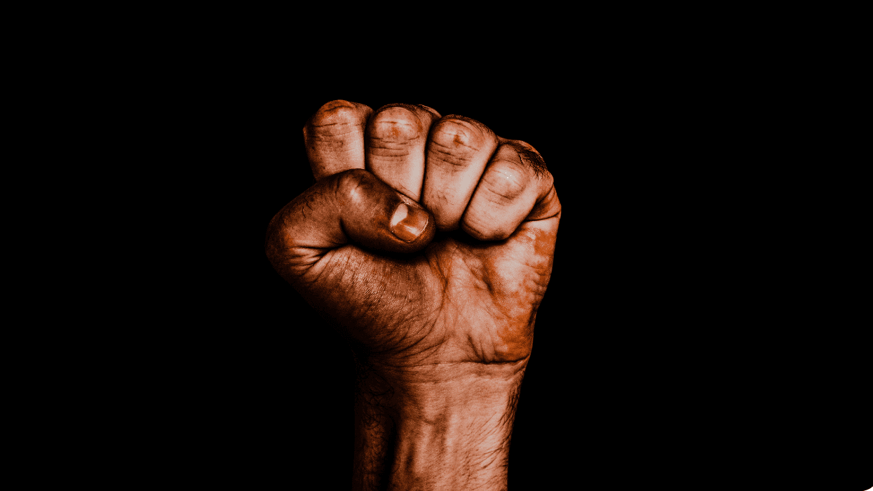 Close-up of a clenched fist against a black background with dramatic lighting