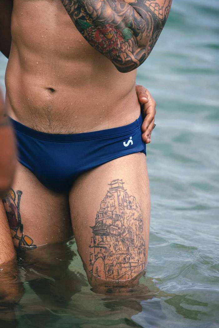 Close-up of a model wearing blue Sniffies swim briefs while standing in the ocean during the Sniffies Summer Swim Collection campaign in Puerto Rico