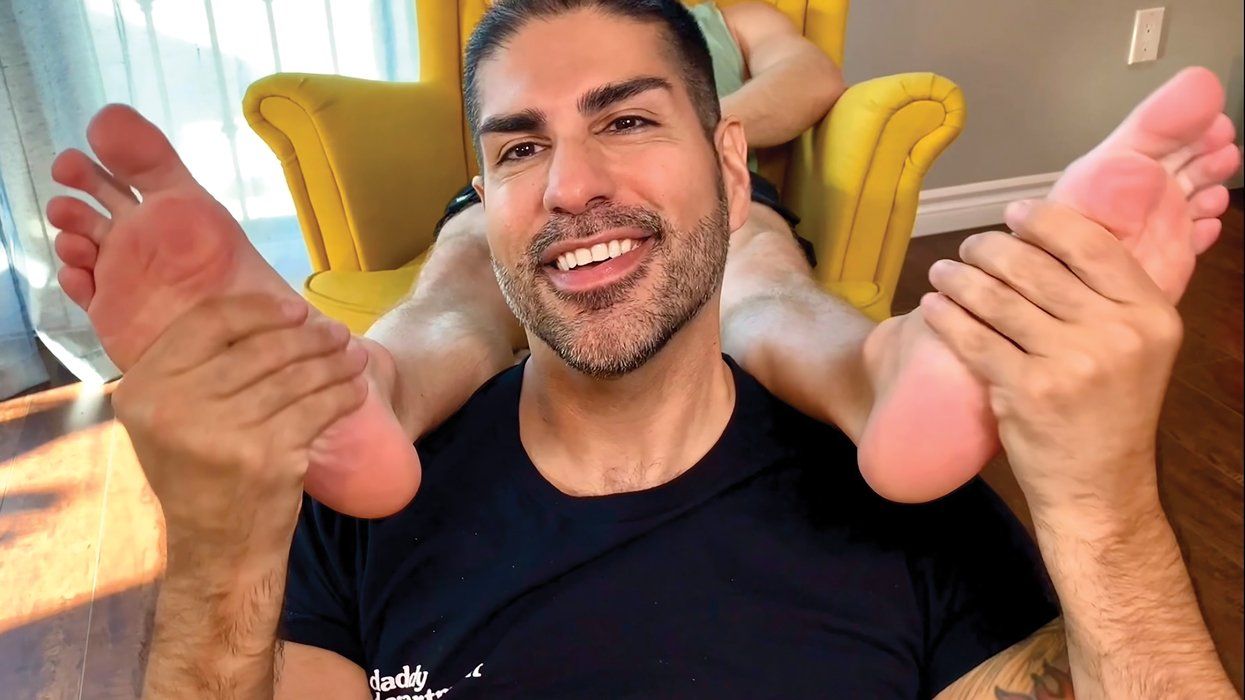 DJGuyRuben holding a person's feet over his shoulder