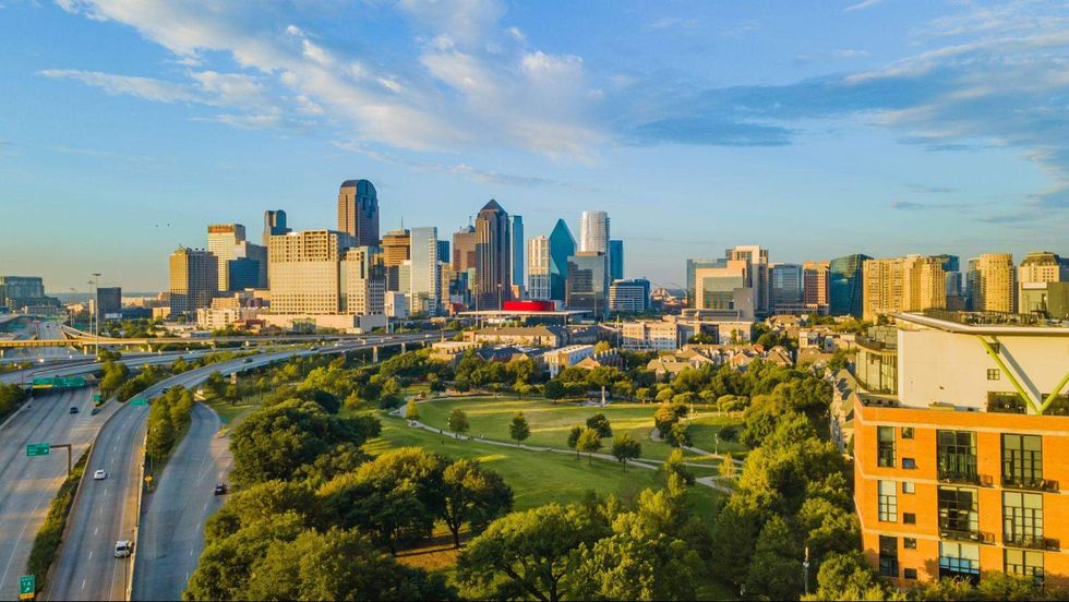Downtown Dallas skyline viewed across Griggs Park on a sunny day.