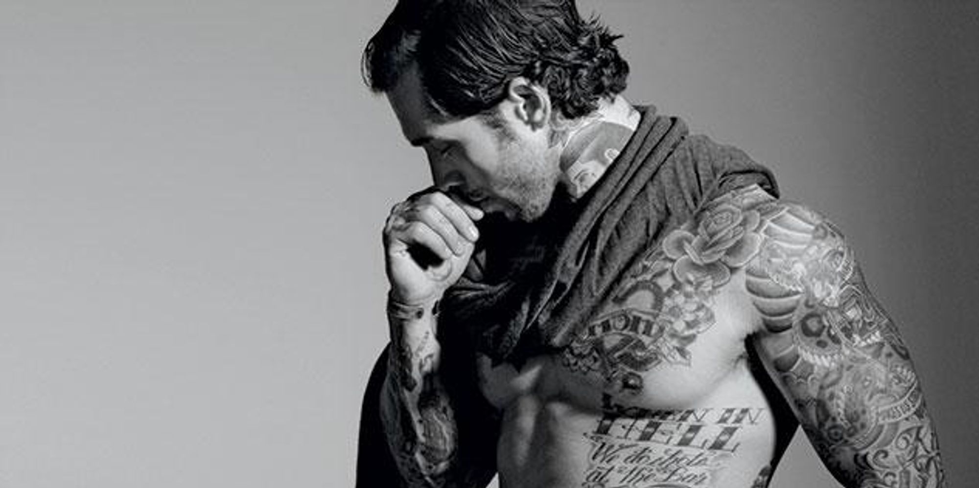 Alex Minsky in a color editorial photograph showing his tattooed arms and torso
