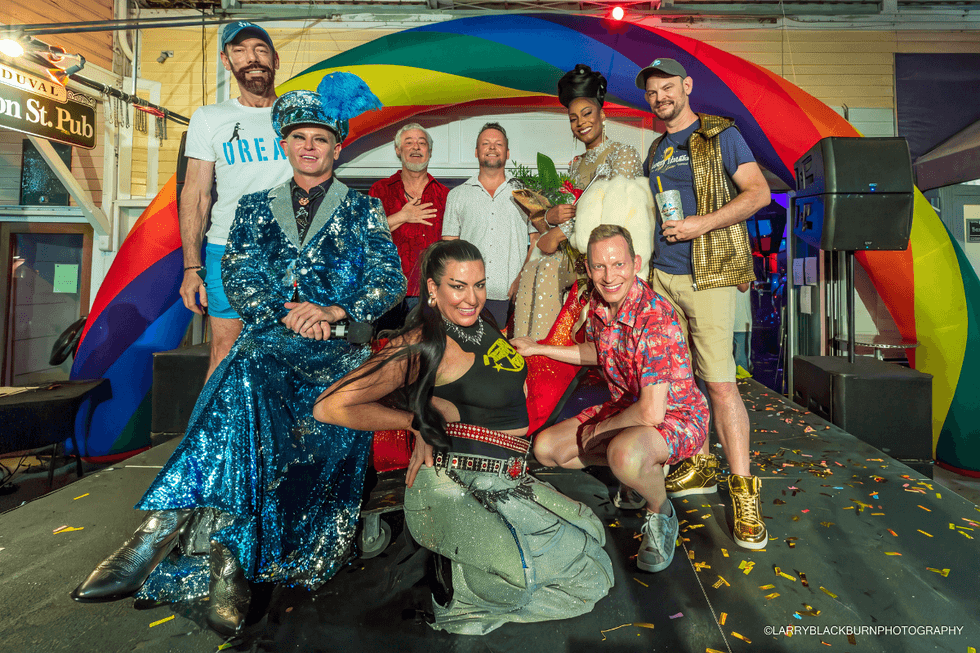 Event attendees pose around Key West's signature giant red high heel during the 2026 If the Shoe Fits national finals.