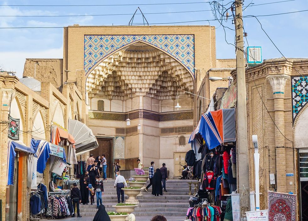 Facade of the Mir Emad Mosque in Kashan Iran Locals walk past the mosque to the bazaar