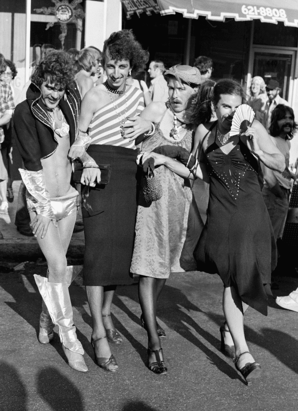 Four people in vintage clothing walk together down a San Francisco street.