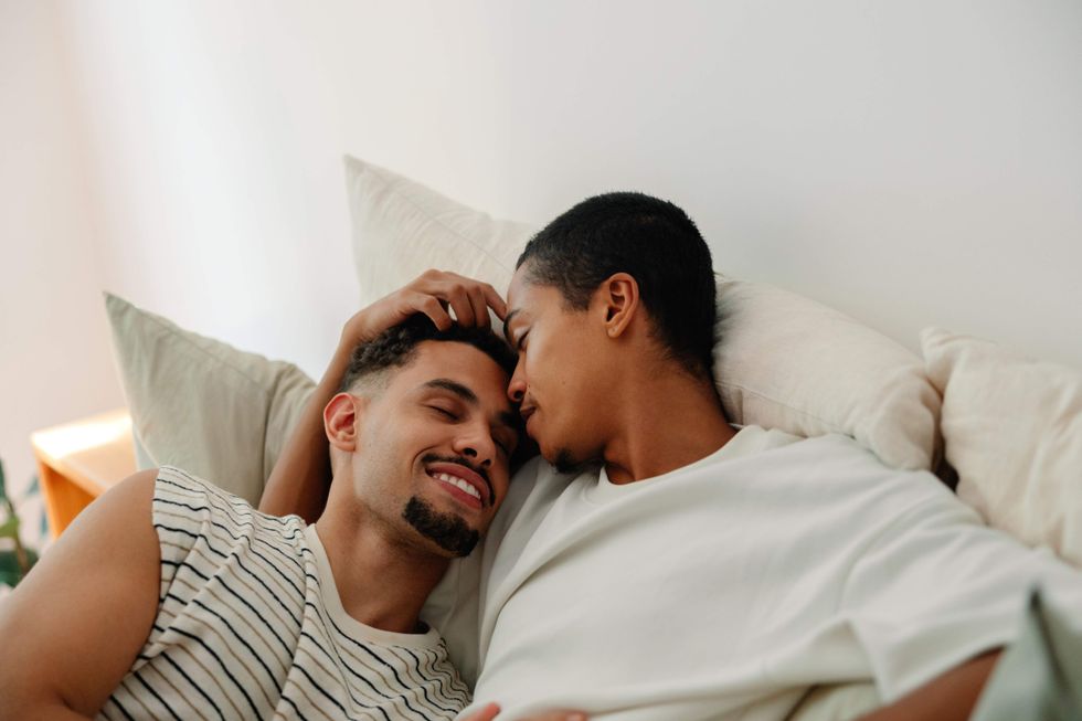 Gay couple snuggling in bed