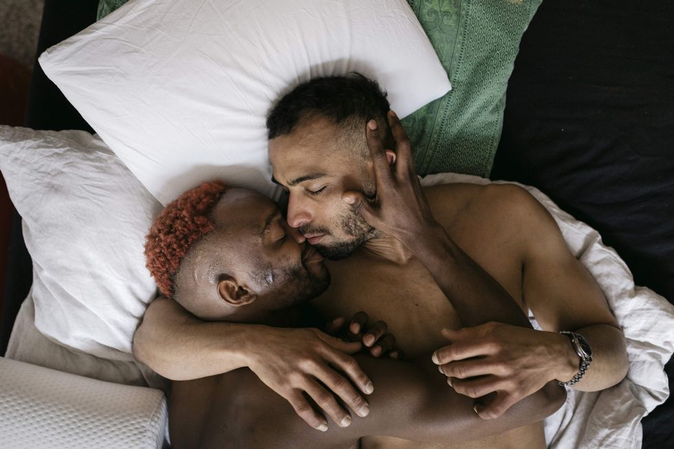 Gay couple snuggling in ned