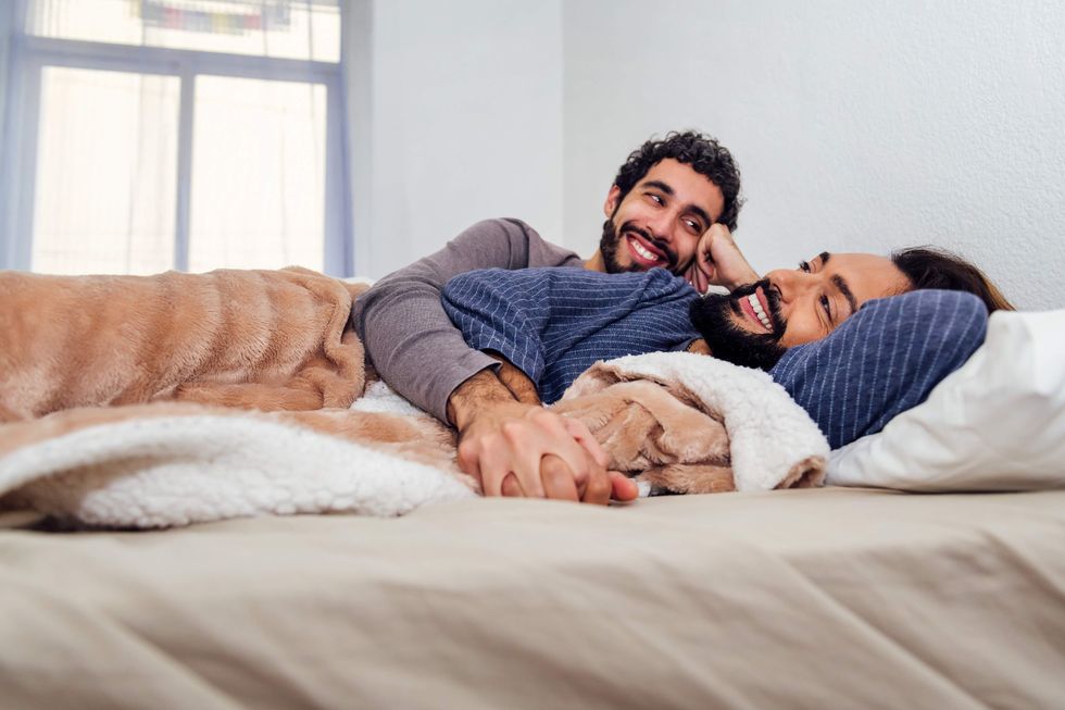 Gay men spooning in bed