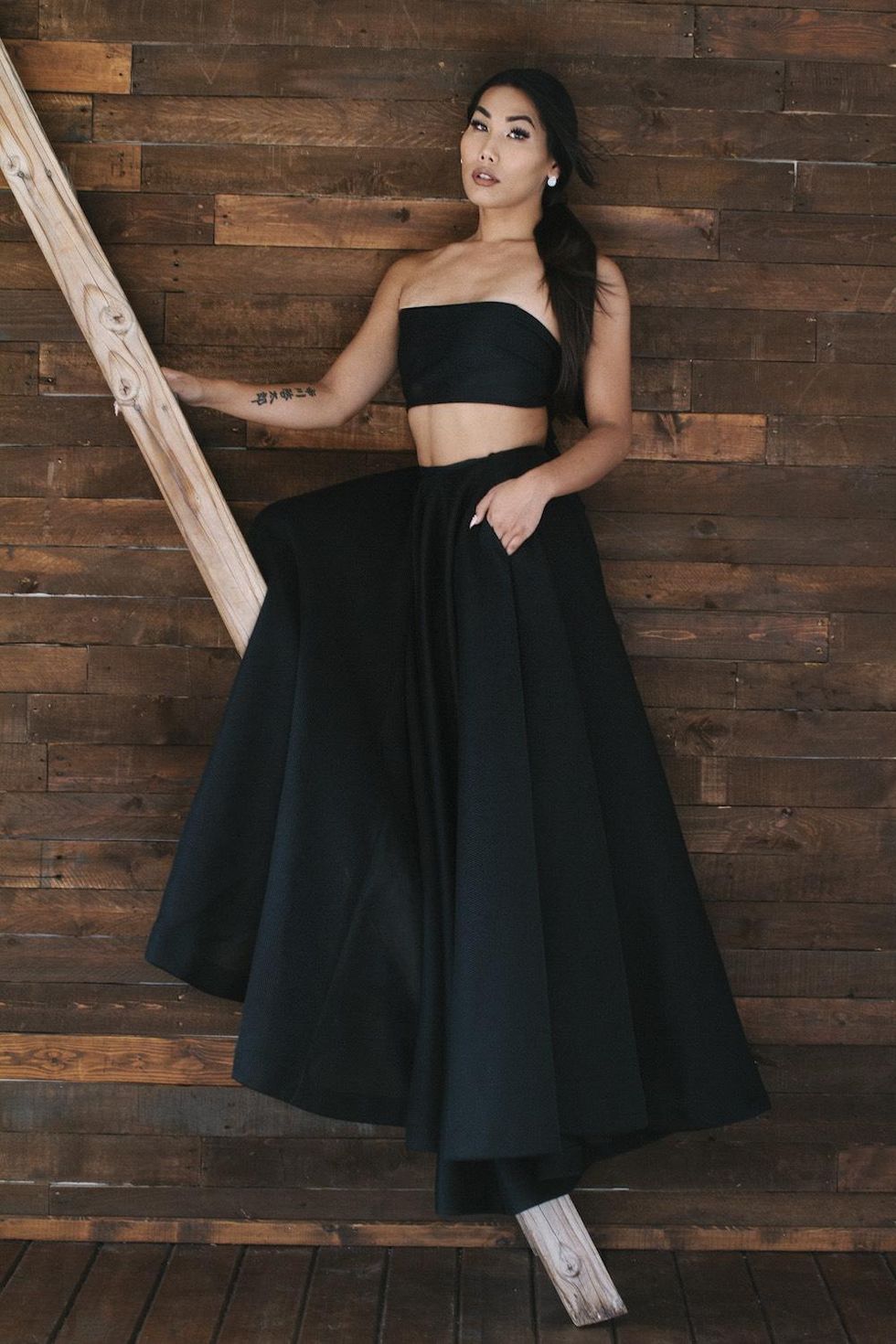 Gia Gunn in Quin black bandeau tie top and skirt.