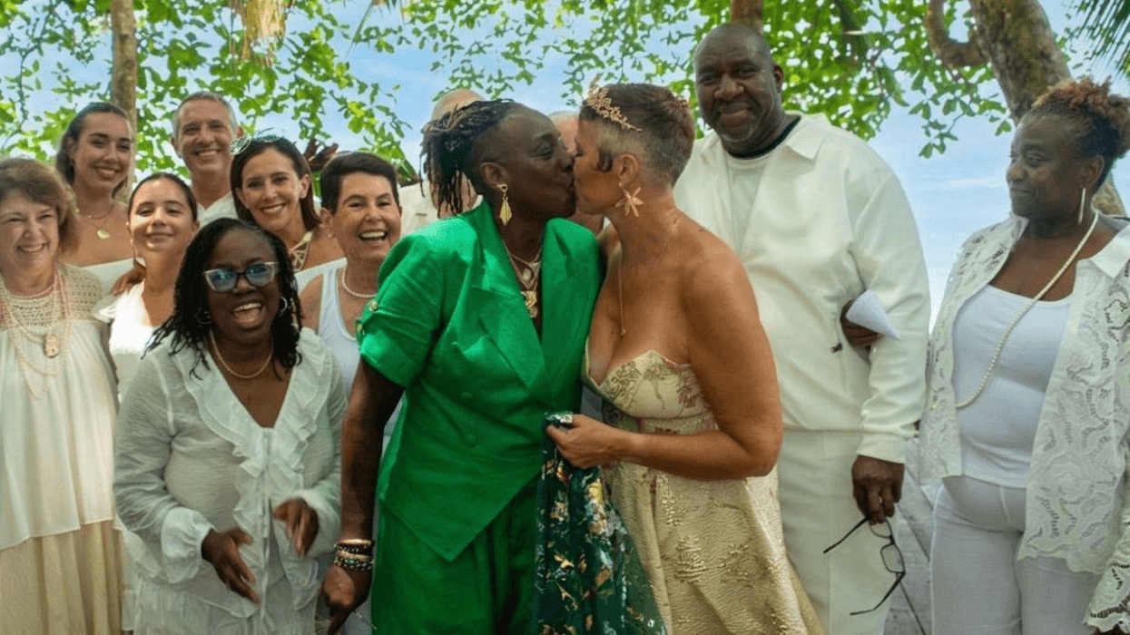 Gina Yashere and Nina Rose Fischer kiss while posing with wedding guests at their Costa Rica ceremony