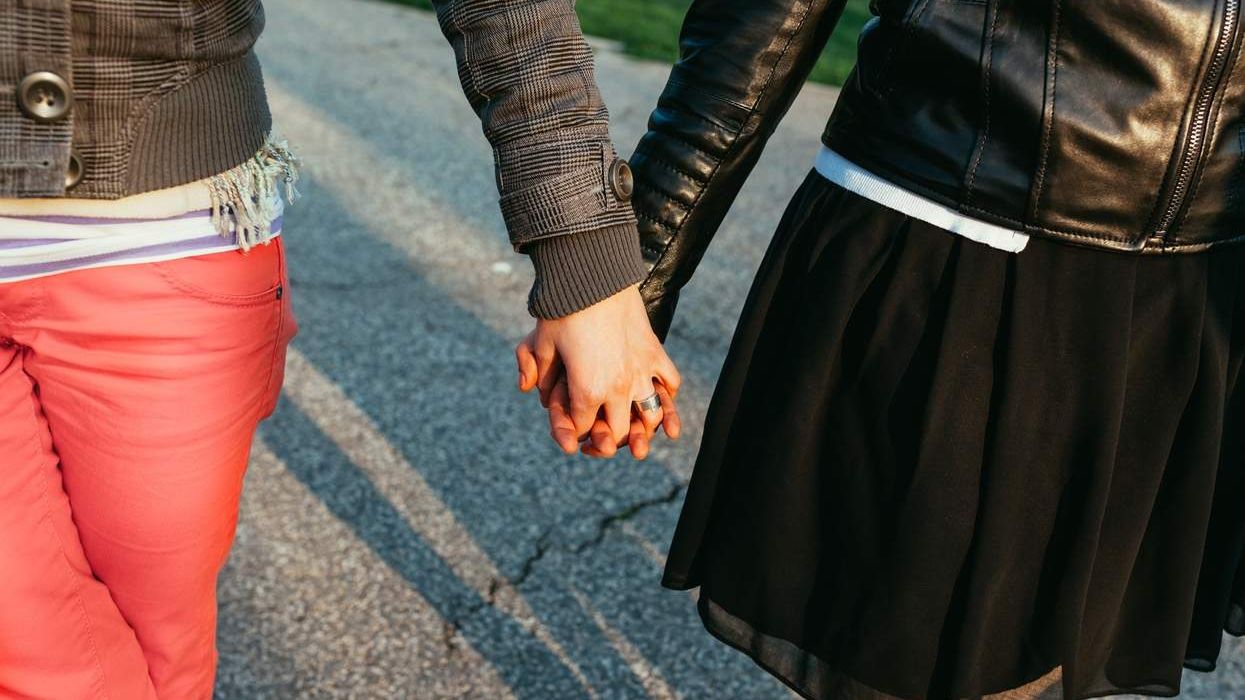 Girls walking hand in hand, in the park